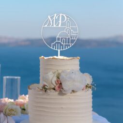 γαμήλια τούρτα με διακοσμητικό τόπερ λευκό με αρχικά και σχέδιο εκκλησία σε ελληνικό μησί