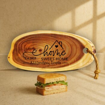 Προσωποποιημένο Ξύλο Σερβιρίσματος Φέτα Κορμού με Χάραξη "Home Sweet Home Est. 2025 - Αλέξανδρος Σοφία". Ρουστίκ ξύλινο πλατώ 52x23 με σάντουιτς σε πάγκο κουζίνας.