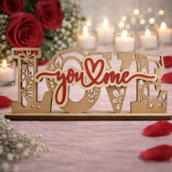 Ξύλινο επιτραπέζιο διακοσμητικό με τη λέξη "LOVE" σε φυσικό χρώμα ξύλου και περίτεχνα σκαλίσματα, που φέρει στο κέντρο την κόκκινη επιγραφή "You & Me" με μια καρδιά, τοποθετημένο σε ρομαντικό φόντο με τριαντάφυλλα και κεριά.
