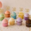 Σειρά από πολύχρωμα cupcakes με χρωματιστό frosting και προσωποποιημένα χρυσά cupcake toppers από plexiglass mirror για πάρτι γενεθλίων.